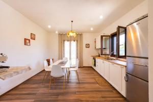 a kitchen with white cabinets and a table and chairs at GuestHost - Barni House in Montesilvano