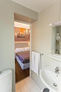 a bathroom with a sink and a bed at Modern Hotel in Paris