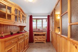 a kitchen with wooden cabinets and a window at Petit Logement Cerise L'écrin d'Ari in Cerise