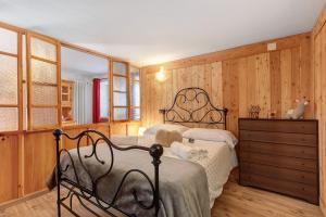 a bedroom with two beds and a wooden wall at Petit Logement Cerise L'écrin d'Ari in Cerise