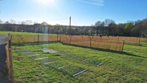 a garden withestones in the grass next to a fence at Camping La Ferme du Guéric in Riec-sur-Bélon