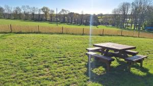 a picnic table in a field with a fountain at Camping La Ferme du Guéric in Riec-sur-Bélon