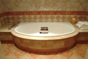 a bath tub with a sink in a bathroom at Hotel Maher in Cintruénigo