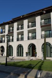 a large white building with a lawn in front of it at CITADEL Heritage Hotel Berat in Berat