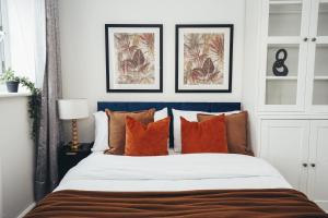 a bedroom with a large bed with orange pillows at 4-Bedroom Family Home in Mickleover - Private Driveway - Spacious Garden in Derby