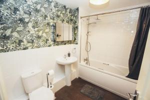 a bathroom with a sink and a toilet and a tub at 4-Bedroom Family Home in Mickleover - Private Driveway - Spacious Garden in Derby +22 photos