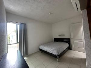 a bedroom with a bed and a window at La Casa del Cenote in Playa del Carmen