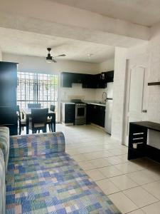 a kitchen and living room with a couch and a table at La Casa del Cenote in Playa del Carmen