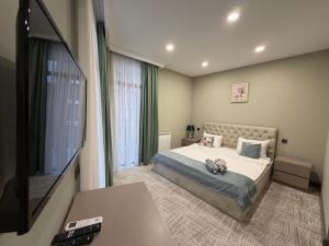 a bedroom with a bed and a flat screen tv at Aurora Hotel Batumi in Batumi
