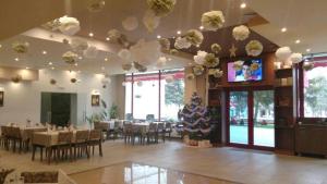 a dining room with tables and chairs and a tv at Kolhida Complex in Elkhovo
