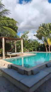 a large swimming pool with blue water and palm trees at Casa MCAYA in Fortim