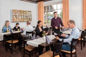 a group of people sitting at tables in a restaurant at Hotel und Restaurant Röbler Thor in Wittstock