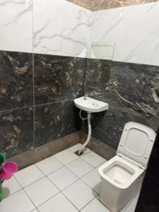 a bathroom with a toilet and a sink at RADHA DEVI GUEST HOUSe in Juliāsar +7 photos