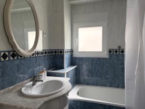 a bathroom with a sink and a mirror and a tub at La Cantora in Sagunto