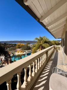 a balcony with a view of a pool and palm trees at Villa La Font Apart Hotel & Spa in Villa Carlos Paz