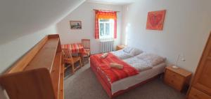 a small bedroom with a bed and a table at Chata Betyna in Pec pod Sněžkou