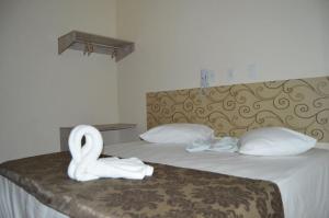 a hotel room with a bed with swans on it at Dom Manuel Hotel in Abaetetuba