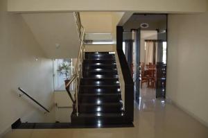 a staircase in a house with a black stair case at Dom Manuel Hotel in Abaetetuba