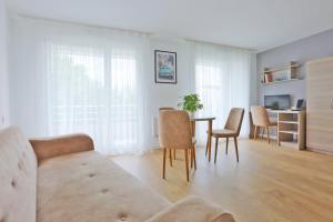 a living room with a couch and a table and chairs at KOSY Appart'Hôtels - La Maison Des Chercheurs in Vandoeuvre-lès-Nancy