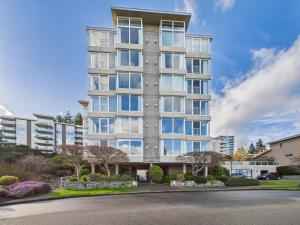 a tall apartment building with a lot of windows at Panoramic Ocean & Fairway Views At Sayward Hill in Victoria