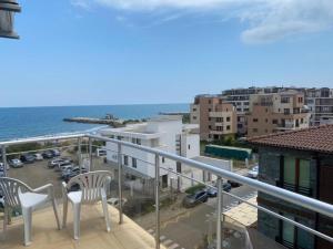 a balcony with two chairs and a view of the ocean at goldenseaview apartment 2 in Pomorie