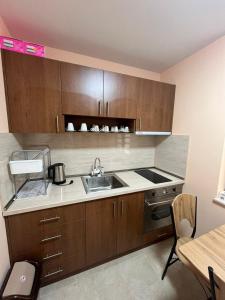 a kitchen with wooden cabinets and a sink at Червената къща in Hisarya