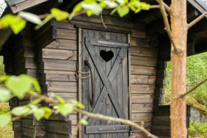 a wooden out house with a heart door at Experience Finland Like a Finn-Private Island Tampere Region in Orivesi