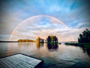 a rainbow over a lake with trees and a dock at Experience Finland Like a Finn-Private Island Tampere Region in Orivesi +27 photos