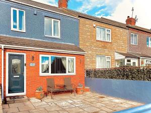 a house with a bench in front of it at Rothsay Beach House in Newbiggin-by-the-Sea