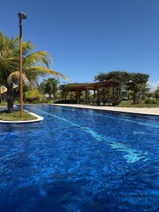 a swimming pool with blue water in a resort at Condomínio Bosque da Praia, casa 193 Jacumã RN in Jacumã