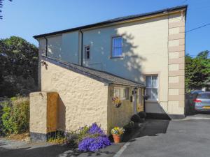 a building with flowers on the side of it at Oak Lodge - Uk49400 in Pembrokeshire