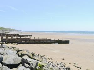 a beach with rocks and a pier on the beach at Oak Lodge - Uk49400 in Pembrokeshire +11 photos