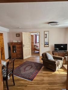 a living room with a couch and a tv at Haus zur Ölmühle 2 in Steinsfeld