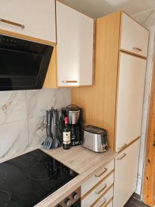a kitchen with white cabinets and a counter top at Haus zur Ölmühle 2 in Steinsfeld +2 photos