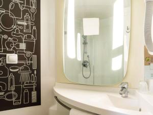 a bathroom with a sink and a mirror at ibis Honfleur in Honfleur +45 photos