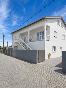 a white building with a staircase on the side of it at Waves beach house in Viana do Castelo +2 photos