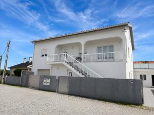 a white house with a fence in front of it at Waves beach house in Viana do Castelo