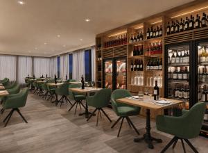 a restaurant with tables and green chairs and wine bottles at PFA Hotel - Viareggio in Viareggio +37 photos