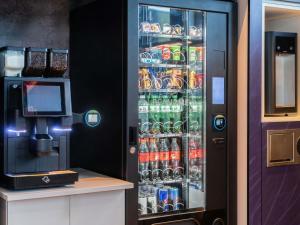 a refrigerator filled with lots of drinks and a television at ibis budget Genève Aéroport in Geneva