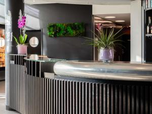 a bathroom with a tub and plants on the wall at Novotel Suites Genève Aéroport in Geneva