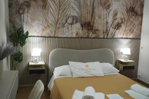 a bedroom with a bed with two tables and two lamps at TROPICAL ROOMS Vista Mare in Cirò Marina