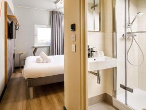 a bathroom with a bed and a sink and a shower at ibis budget Birmingham Centre in Birmingham +87 photos