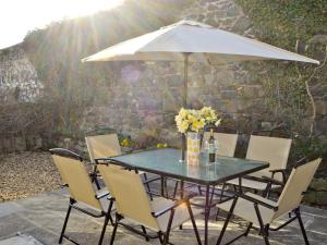 ein Tisch und Stühle mit einem Sonnenschirm auf einer Terrasse in der Unterkunft Craster View in Craster + 13 Fotos