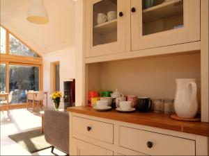 a kitchen with white cabinets and a wooden counter top at Dingle Garden Townhouse in Dingle