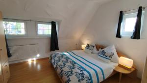 a bedroom with a bed and two windows at Ferienwohnung Daun in Daun