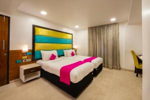 a bedroom with a large bed with a colorful headboard at La Woods Hotel in Chennai