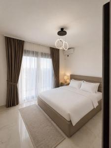 a bedroom with a large white bed and a window at Villa Deromano in Šušanj +18 photos