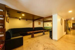 a living room with a couch and a table at La Woods Hotel in Chennai