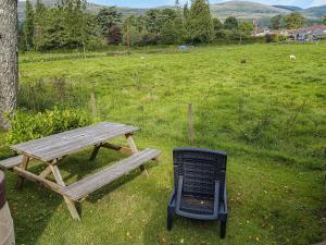 a picnic table and a grill next to a field at Glenbeagles Lodge in Dollar