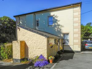 a building with purple flowers in front of it at The Garden Lodge Flat - Uk49415 in Pembrokeshire
